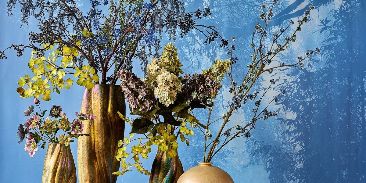 Zijden bloemen en takken tegen een blauwe lucht