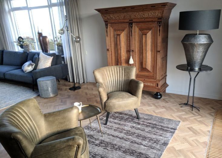 Antieke kast met gouden fauteuil in een woonhuis in IJsselmuiden