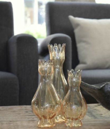 Amberkleurig glaswerk op een houten tafel in het woonhuis in IJsselmuiden